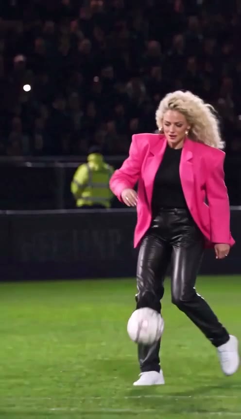 Beat 1: the goalkeeper dives past a woman in a pink blazer on the ball